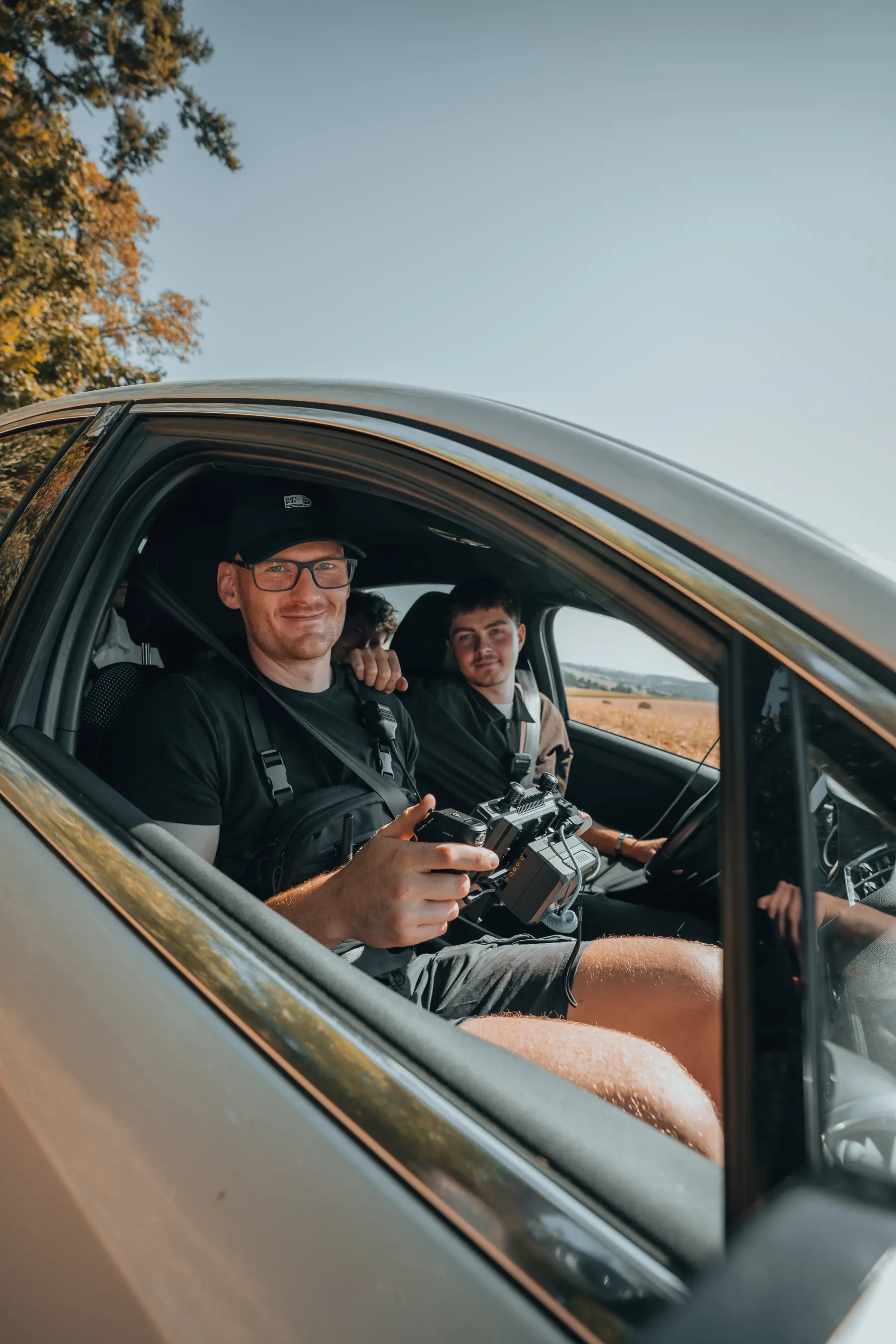 Bastian Obitz und ein Kollege sitzen mit Kamera im Auto und blicken durch das offene Fenster